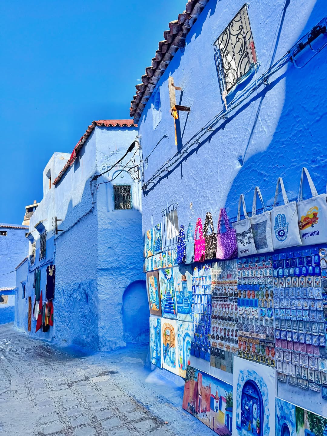 Colorful artisan crafts on a vivid blue wall in Chefchaouen