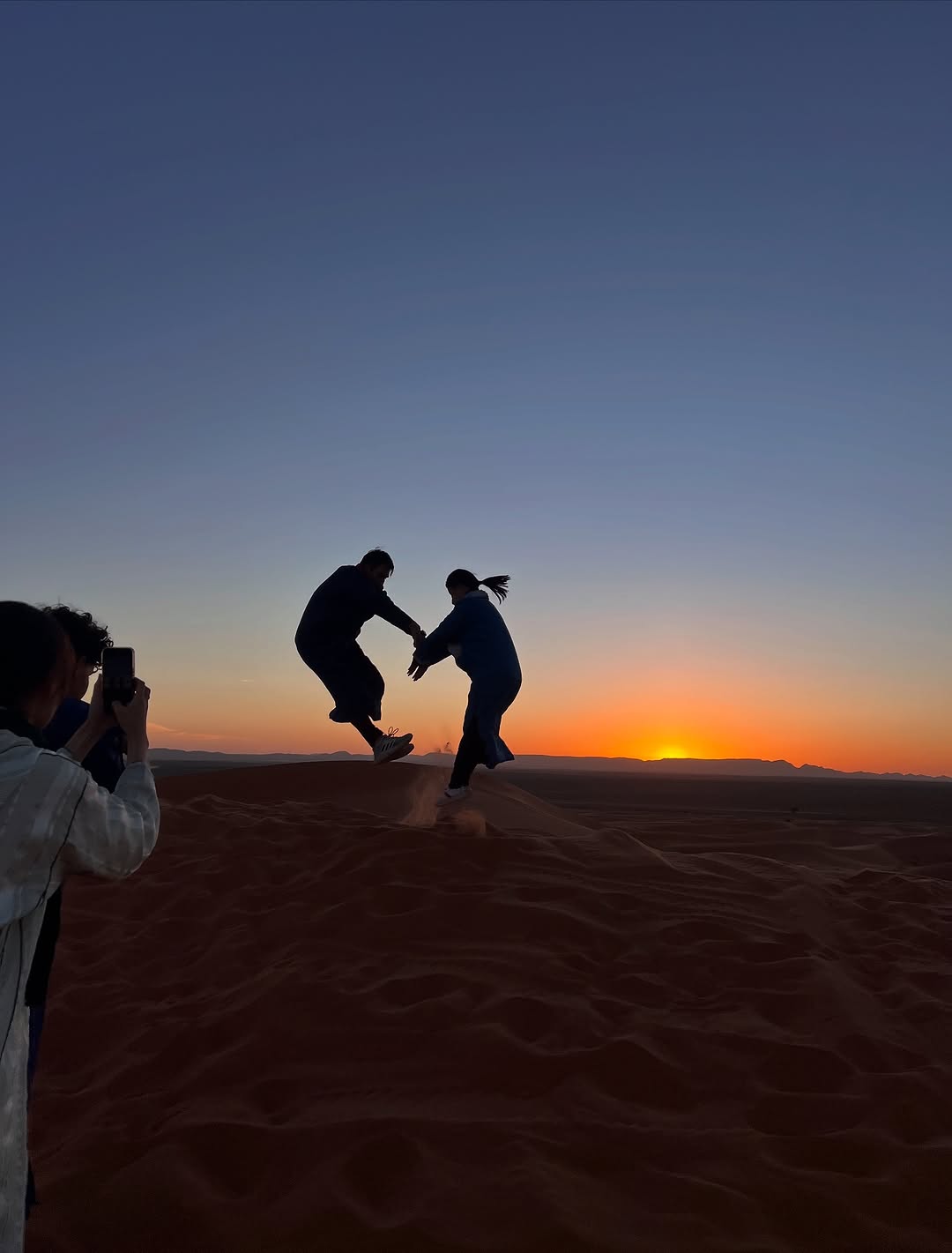 Sunset on the Dunes Travellers jumping on a dune at sunset, Merzouga Sahara