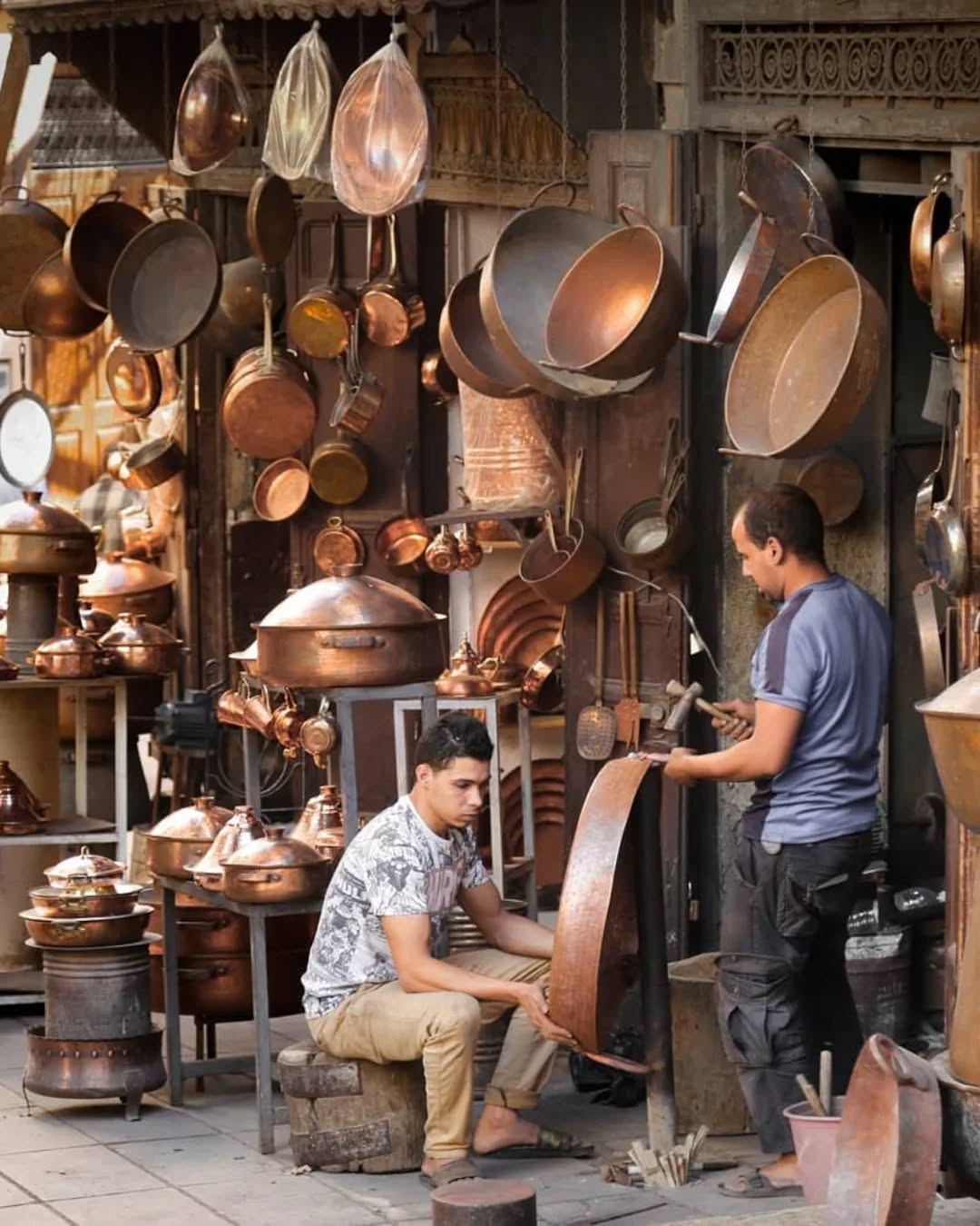 Seffarine Coppersmiths Two coppersmiths working hand-beaten pots in their Seffarine workshop, Fes