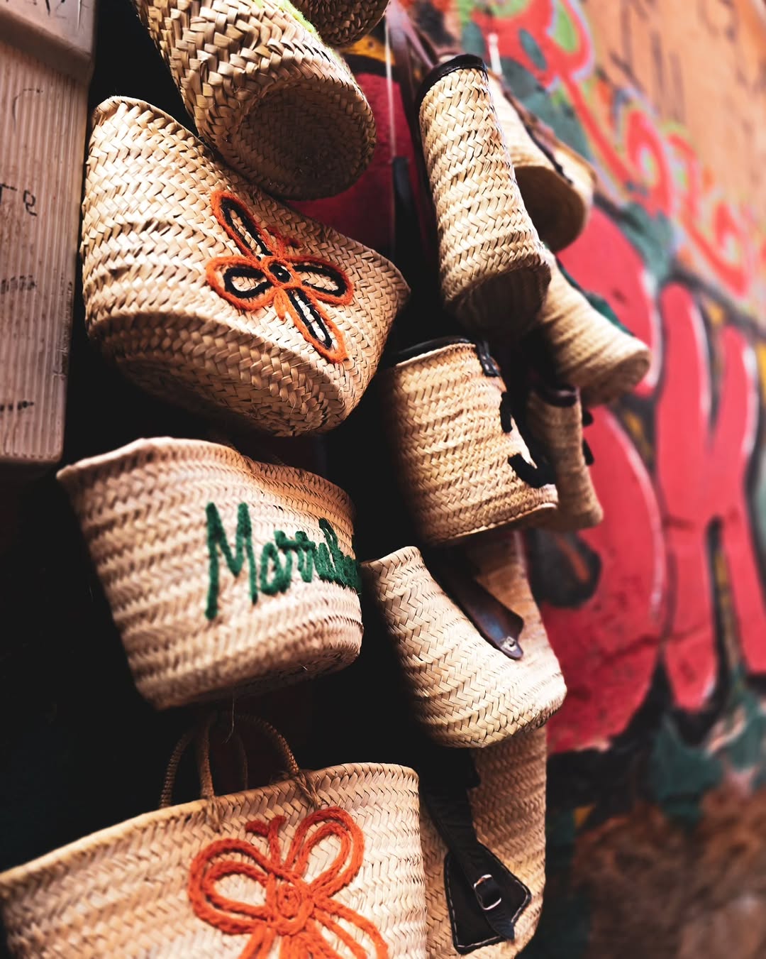 Souk Baskets Embroidered straw baskets reading 'Marrakech' in a souk stall