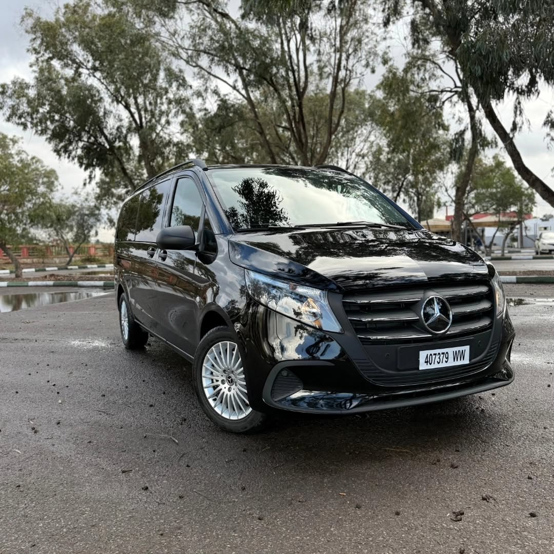 Black Mercedes-Benz Vito private transfer van parked under eucalyptus trees in Morocco