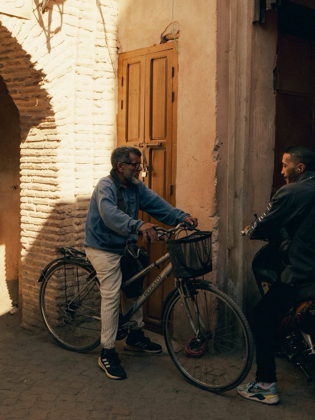 Medina Life Local with a bicycle in a Marrakech medina alley