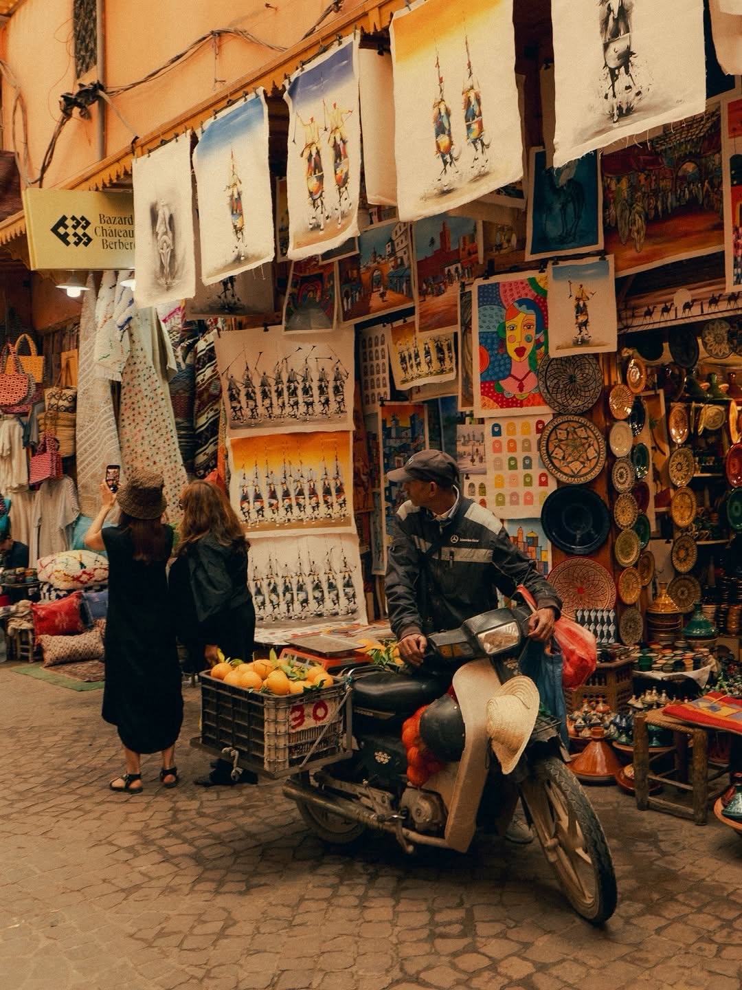 Art Bazaar Art bazaar in the Marrakech souk with paintings, ceramics and a vendor on a moped