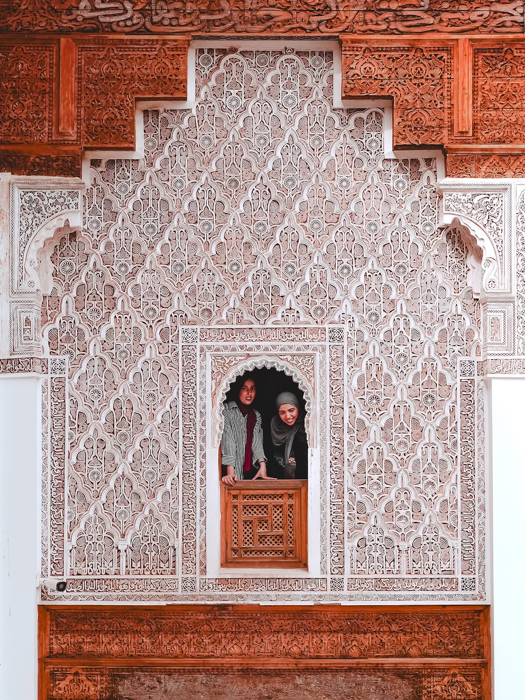 Madrasa Window Visitors at a carved window of Ben Youssef Madrasa, Marrakech